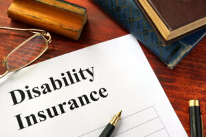 Disability insurance on a office table with a pen.