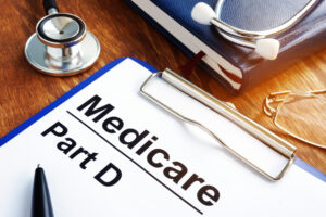 Medicare Part D documents with clipboard on a desk.